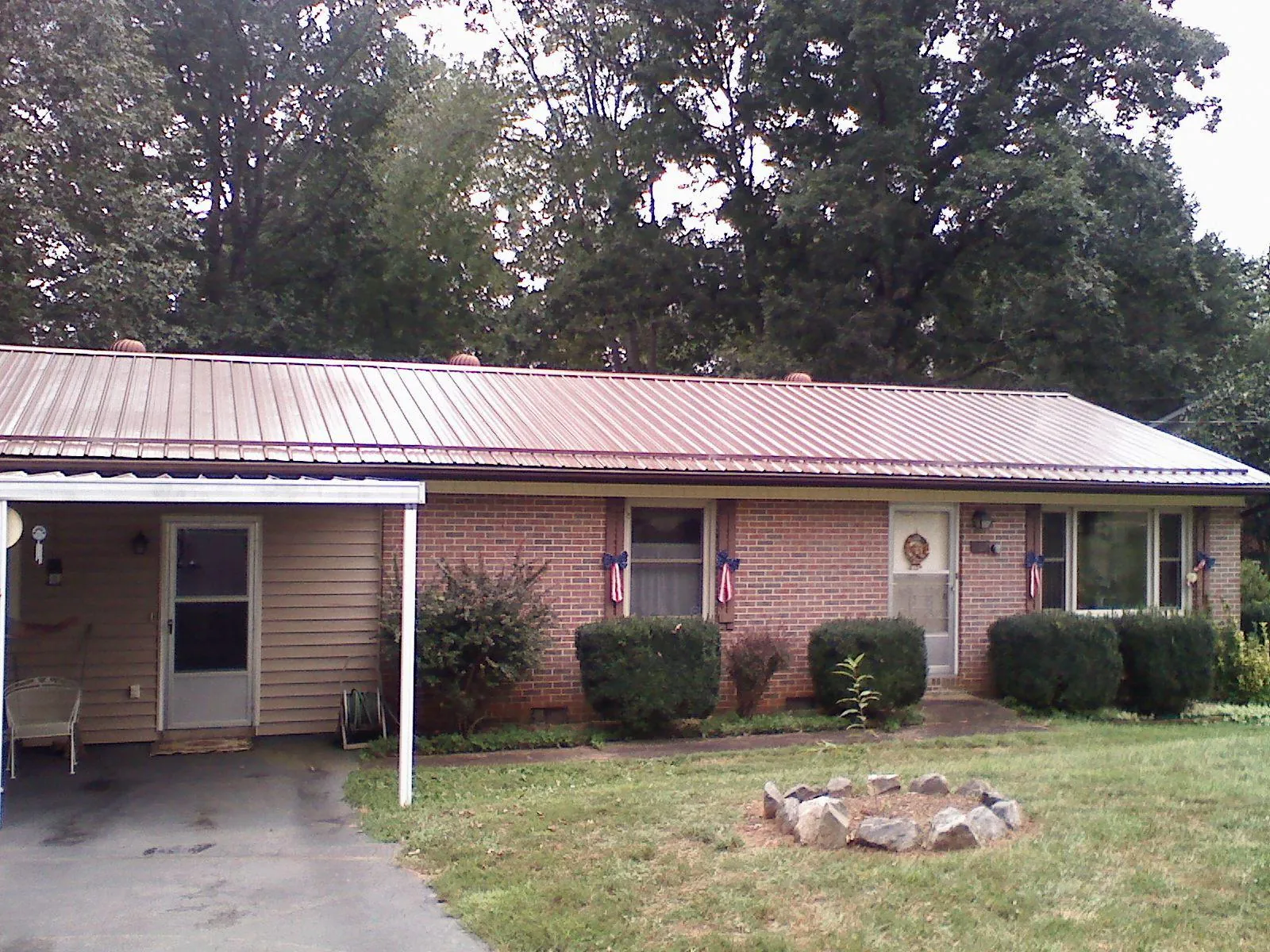 Bronze metal roof and carport on a brick ranch home — Roof Repair work by our crew in Kannapolis